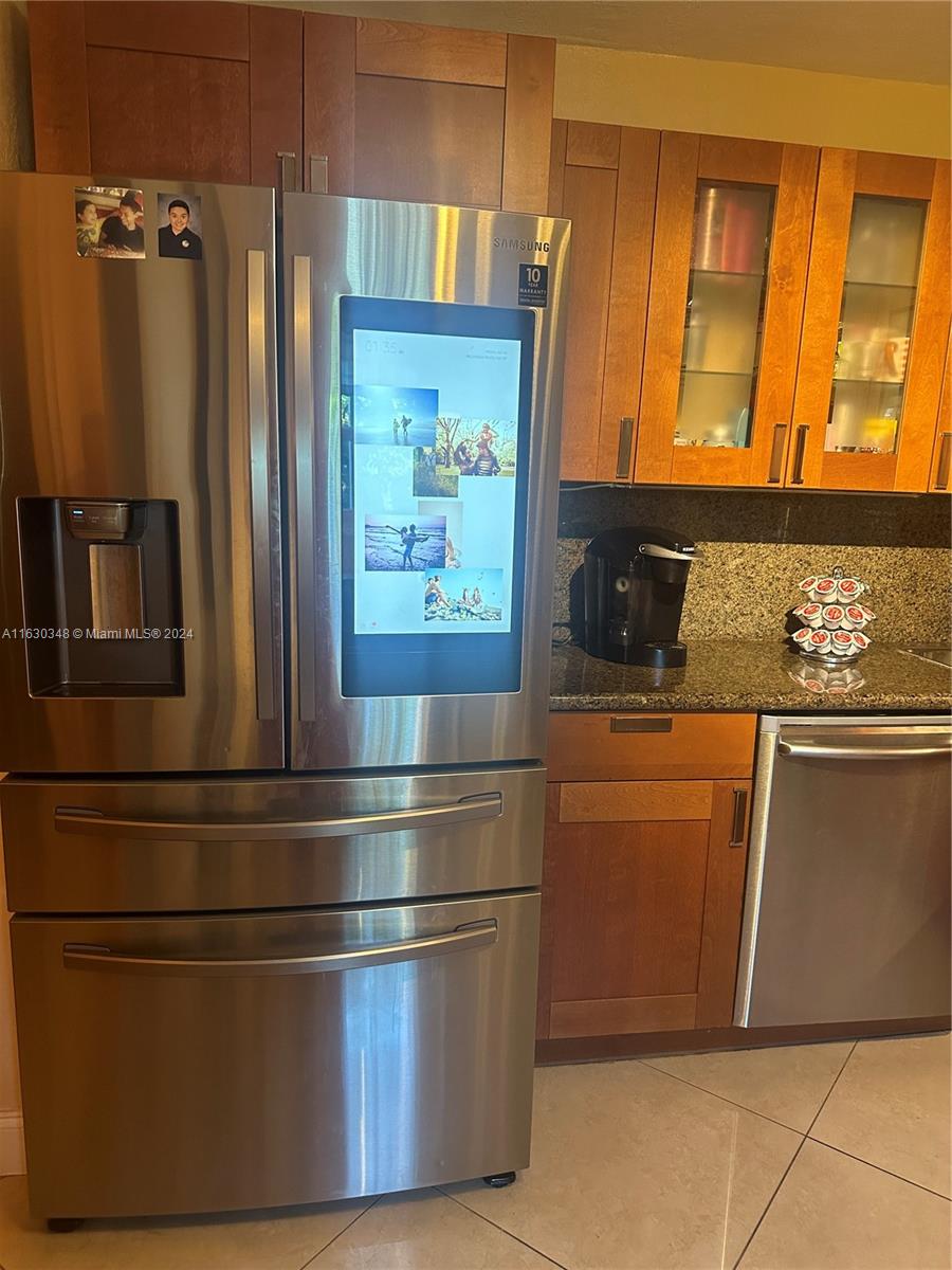 a kitchen with stainless steel appliances granite countertop a refrigerator and a sink