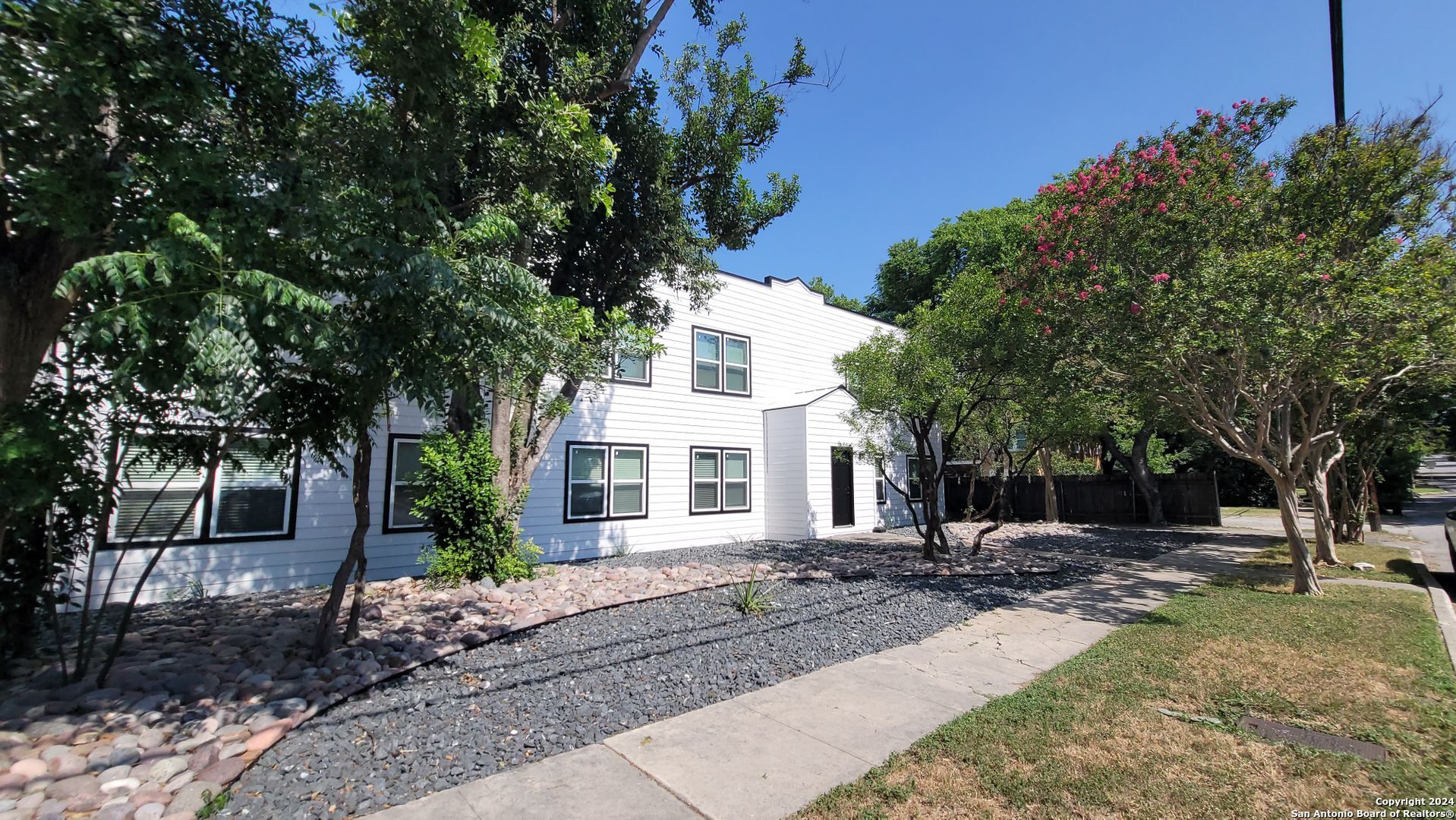 a front view of a house with a garden