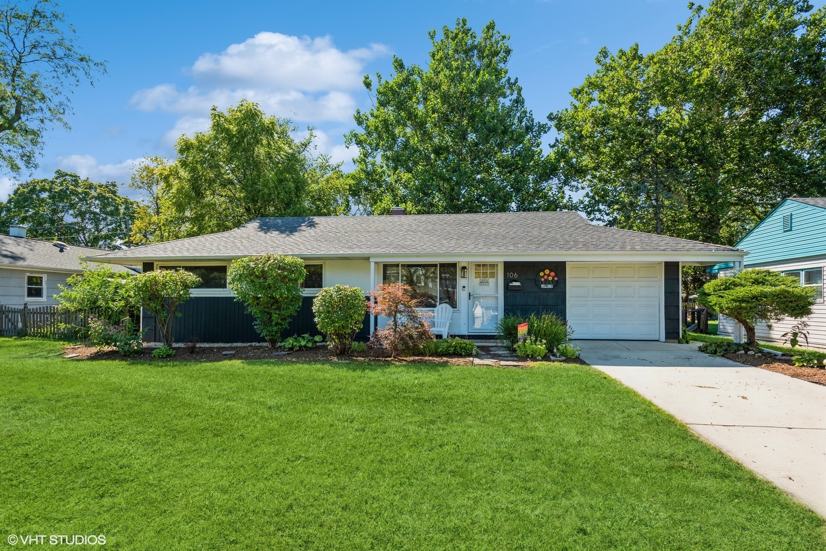 front view of a house with a yard and trees