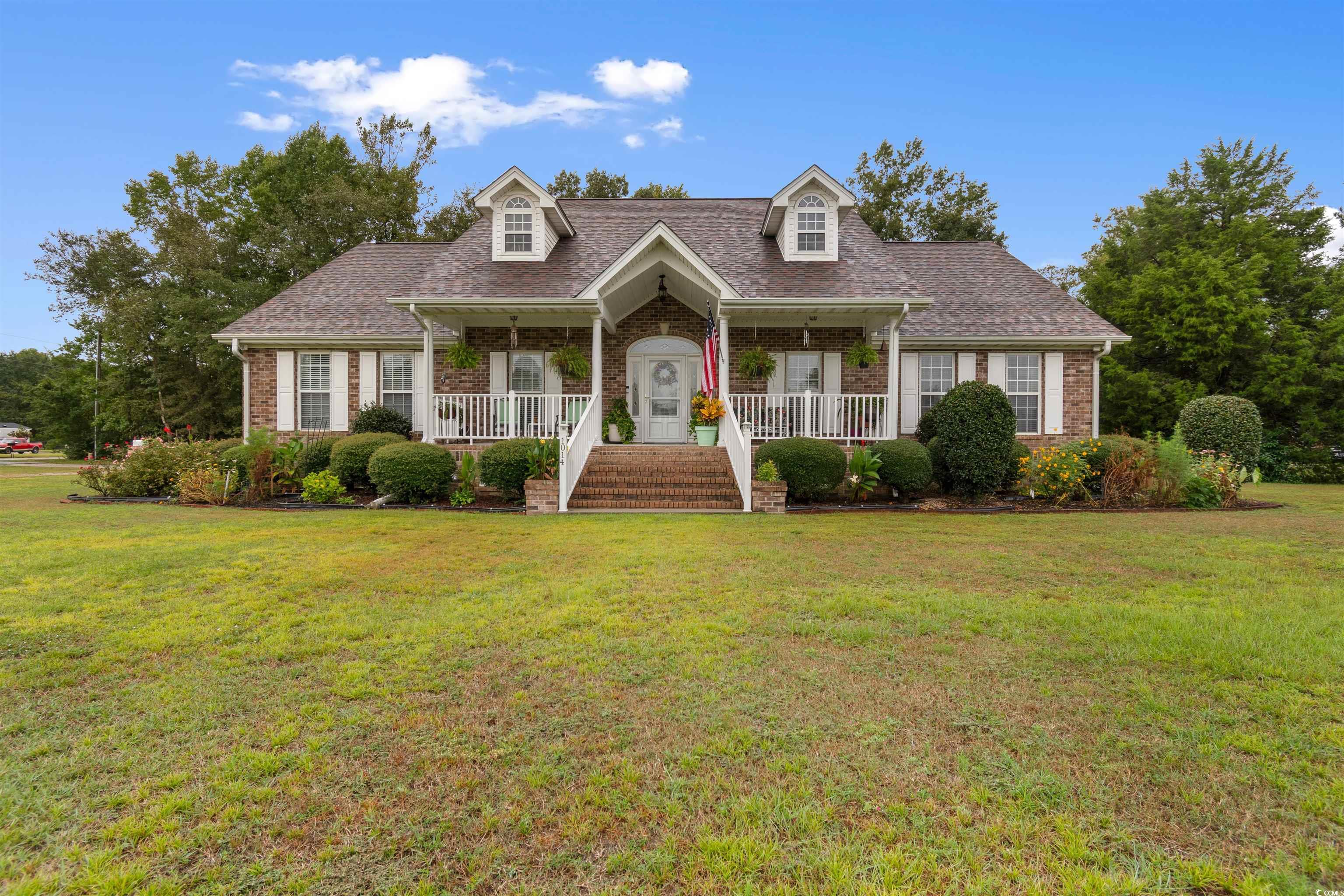 Cape cod house with covered porch and a front yard