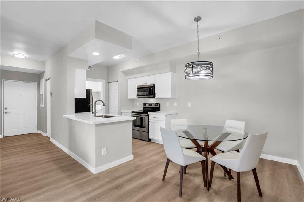 Kitchen featuring appliances with stainless steel finishes, sink, light hardwood / wood-style floors, and white cabinetry