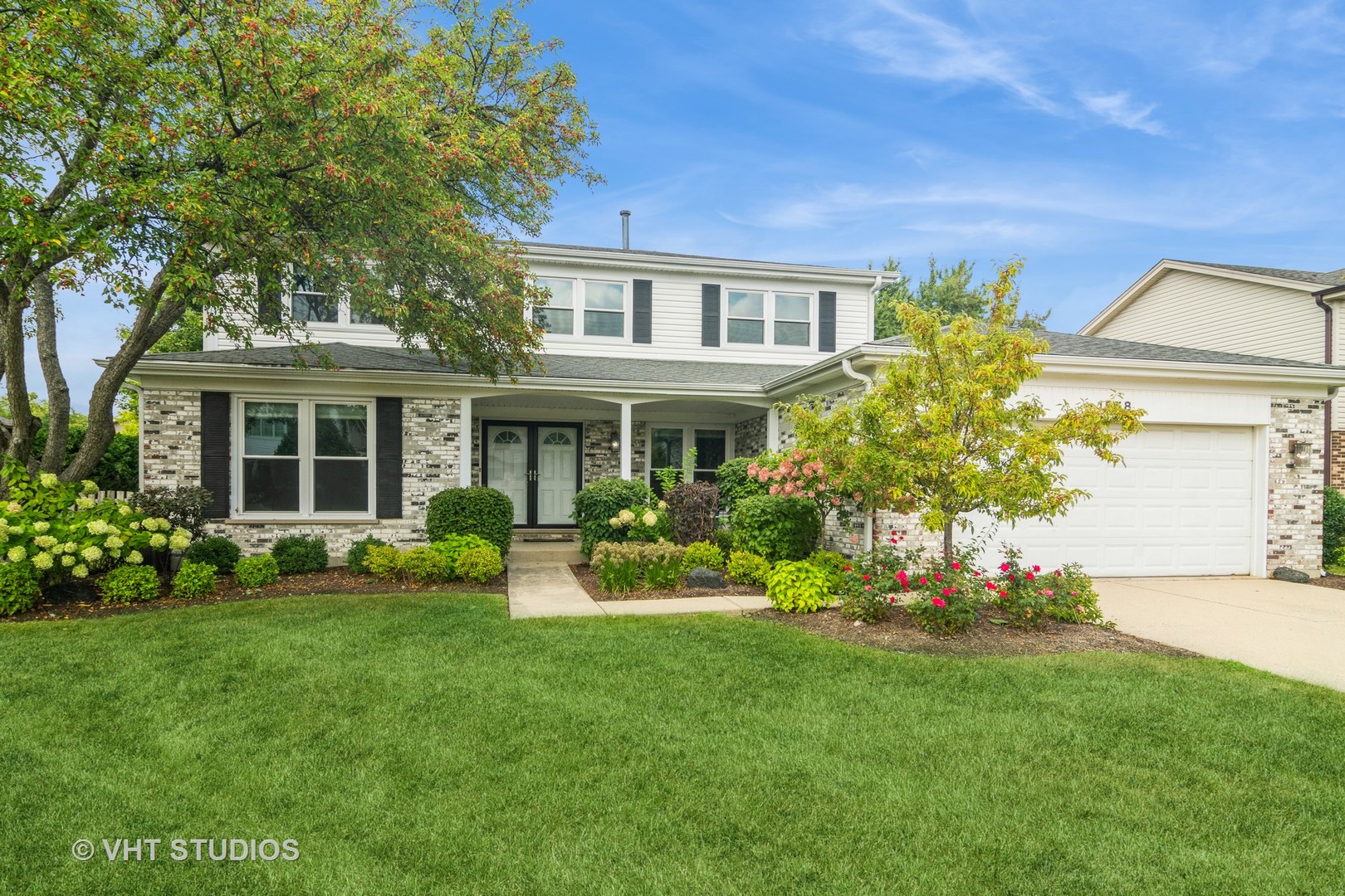 a front view of a house with a yard and potted plants