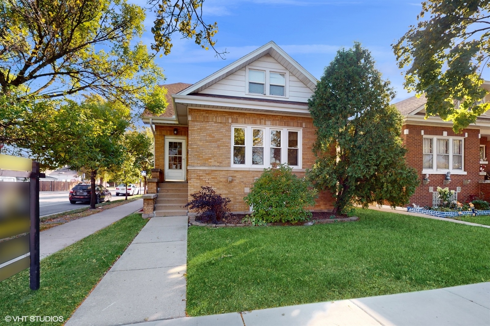 a front view of a house with a yard and trees