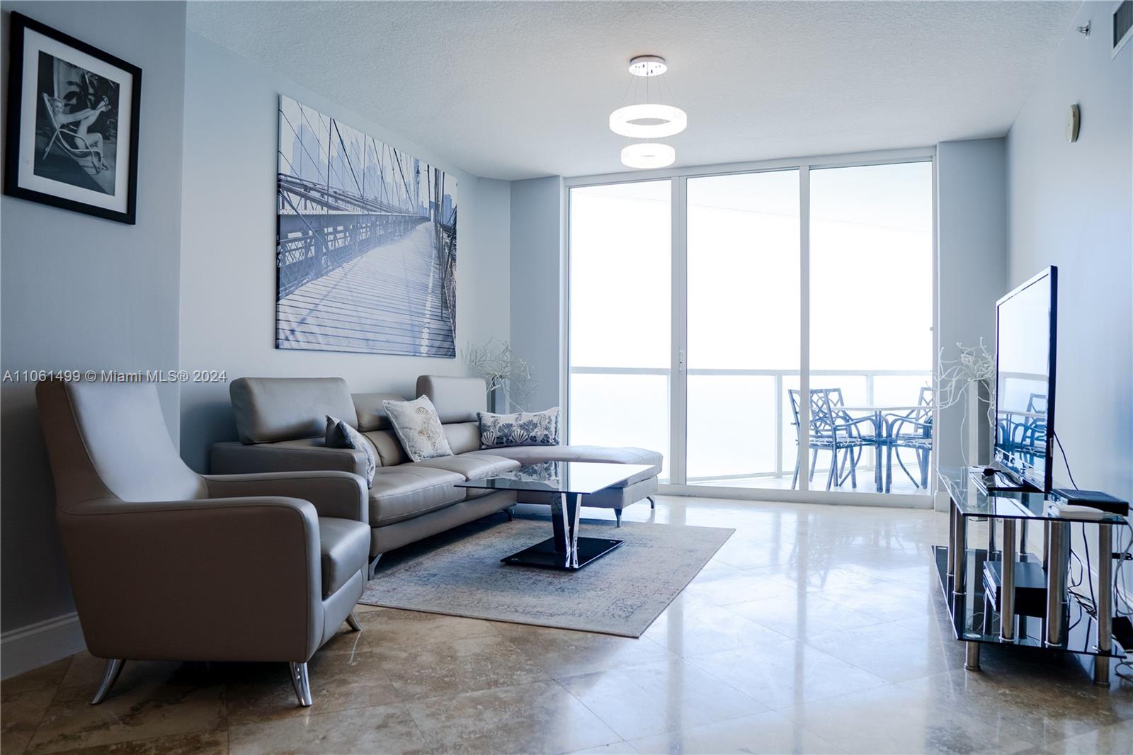 a living room with furniture a large window and a flat screen tv