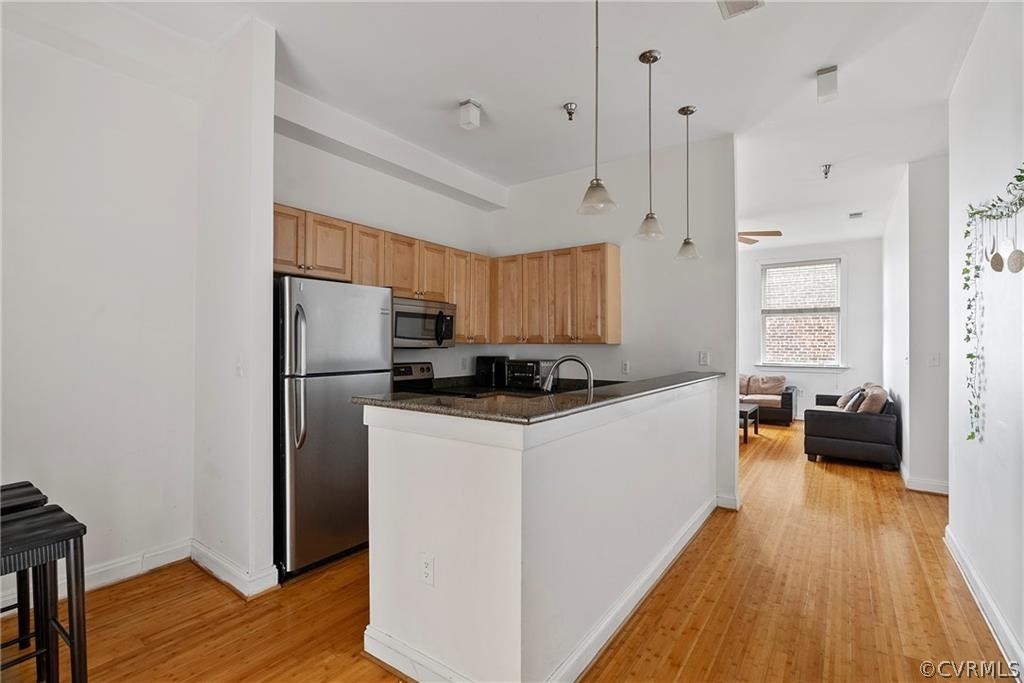 a kitchen with sink a refrigerator and wooden floor