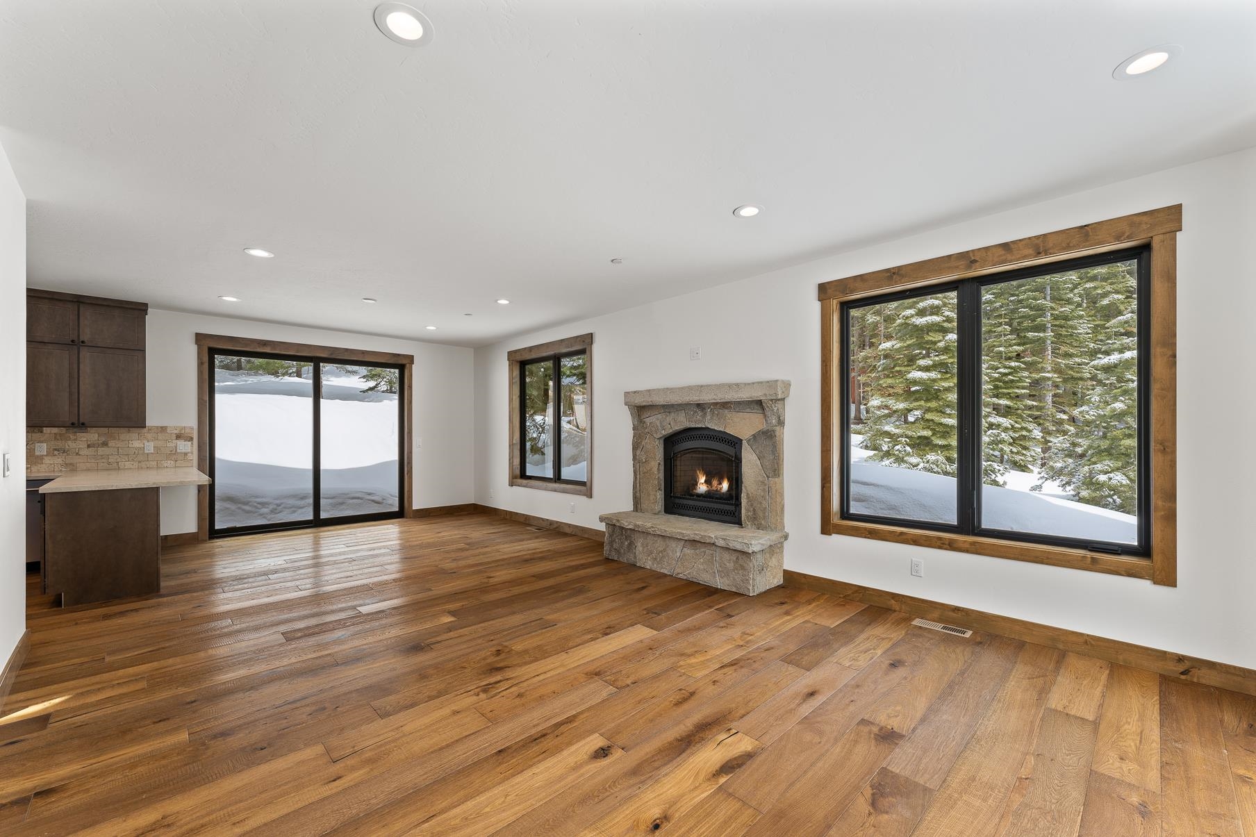 a view of empty room with wooden floor and fireplace