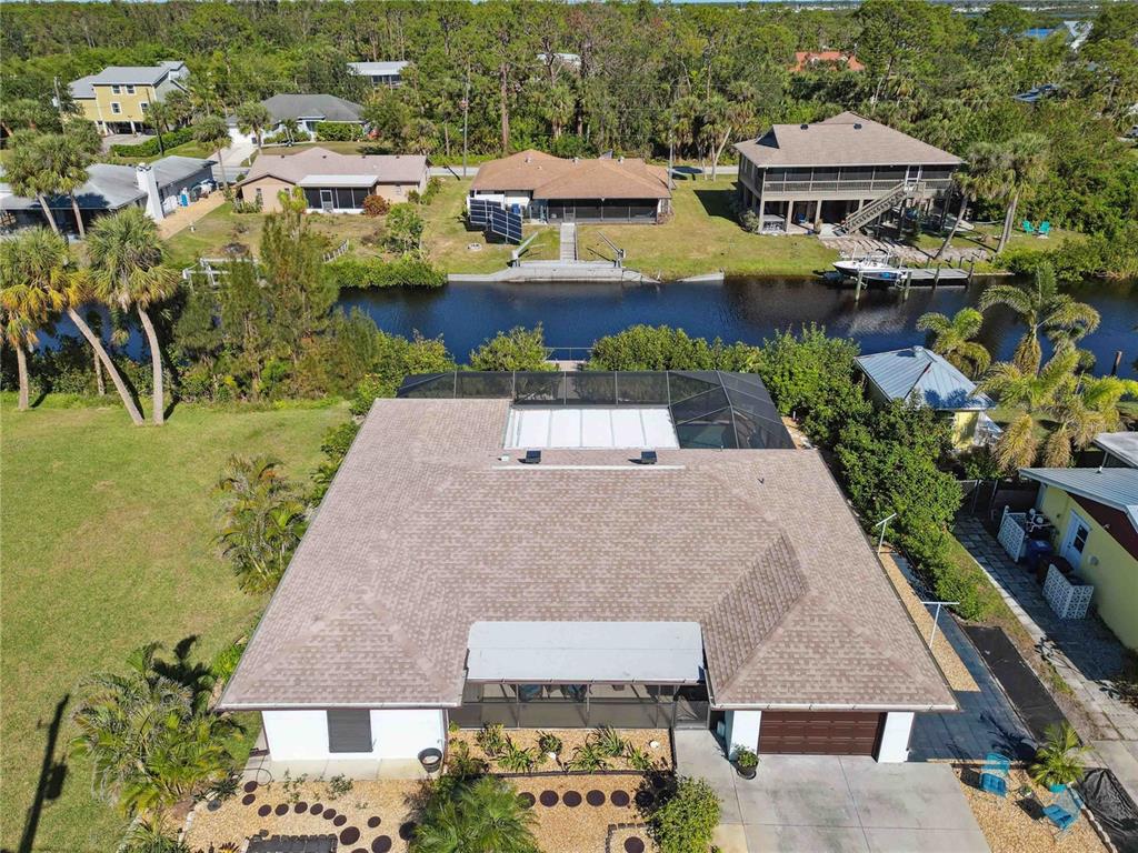 an aerial view of a house with a garden and lake view