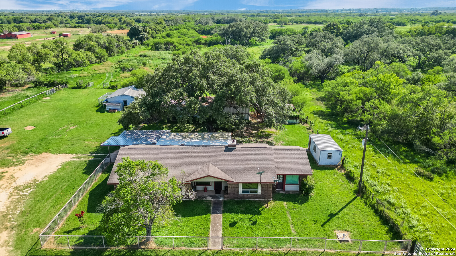 an aerial view of a house with yard and green space