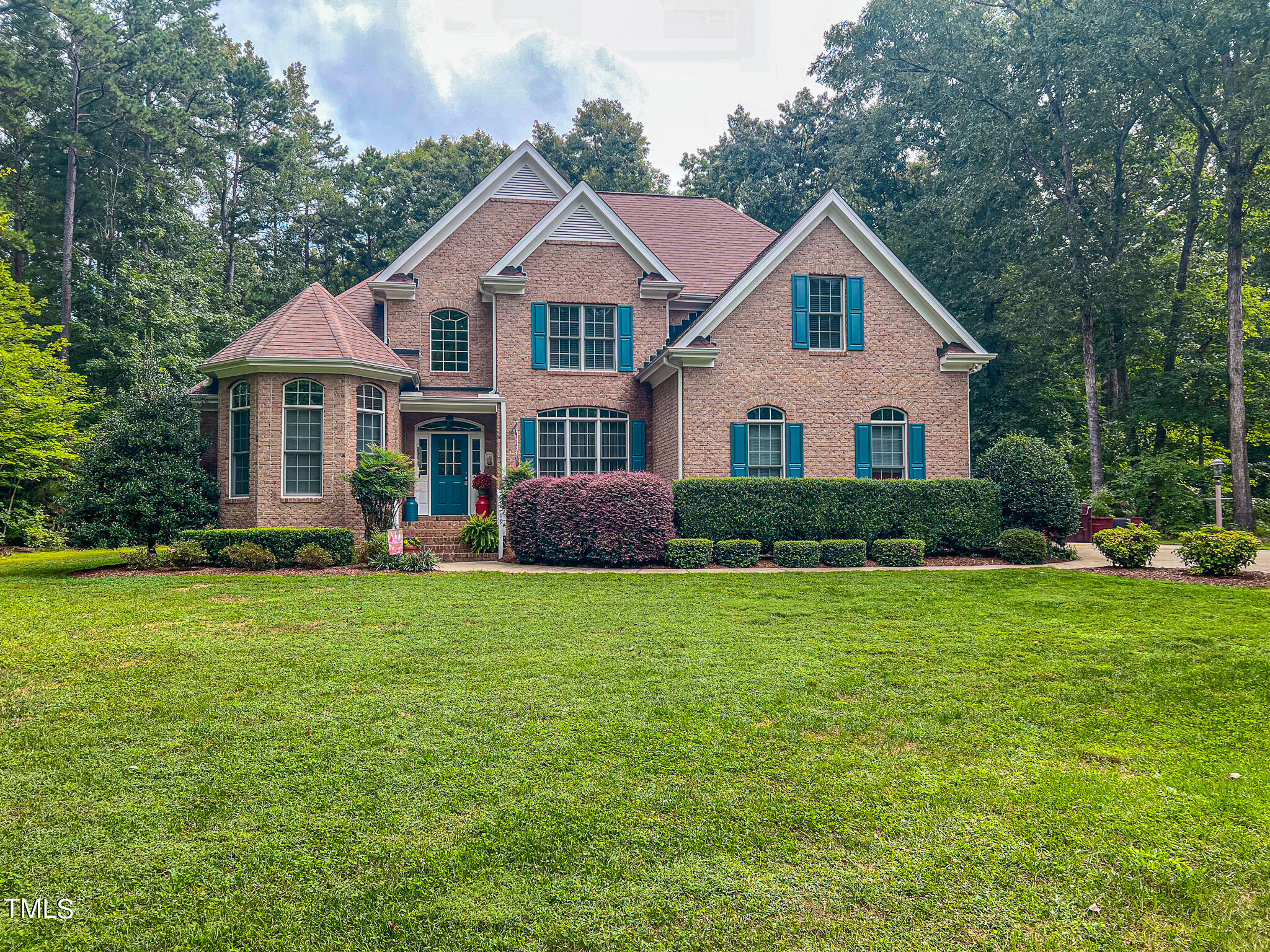 a front view of a house with a yard and trees