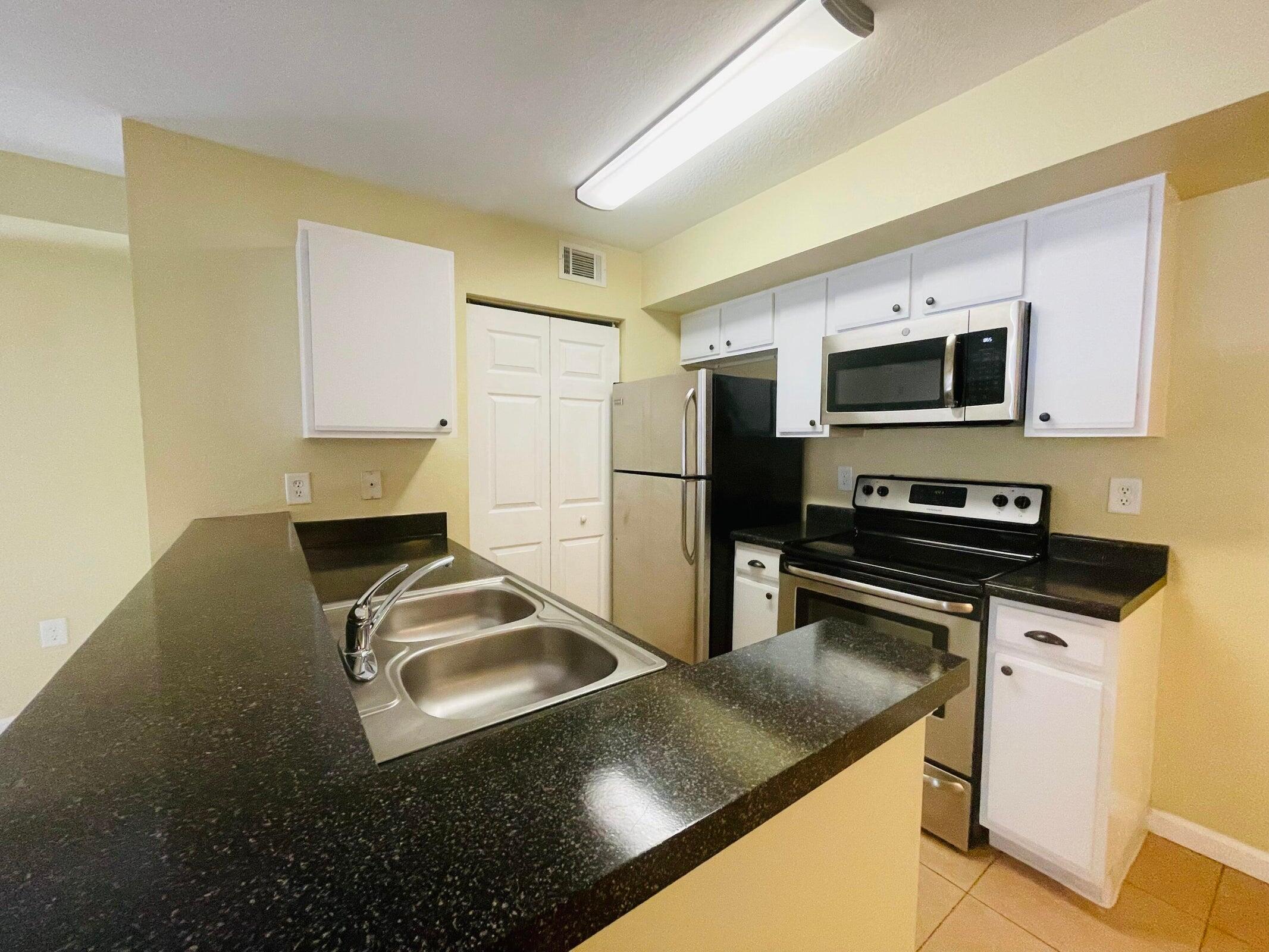 a kitchen with a sink stove and refrigerator