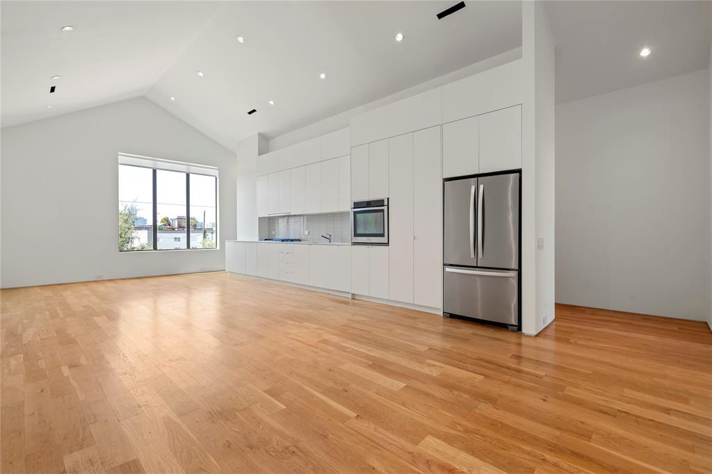 a view of empty room with wooden floor and window