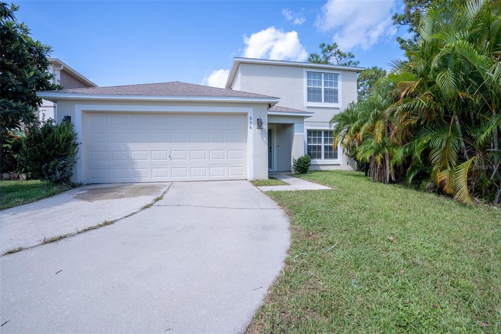 a front view of a house with a yard and a garage