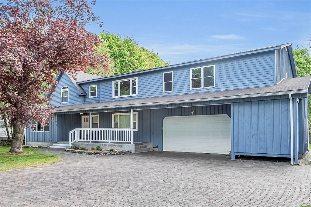 a front view of a house with garden and parking