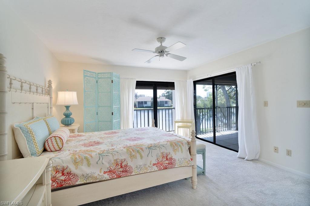 a bedroom with a large bed and a chandelier fan