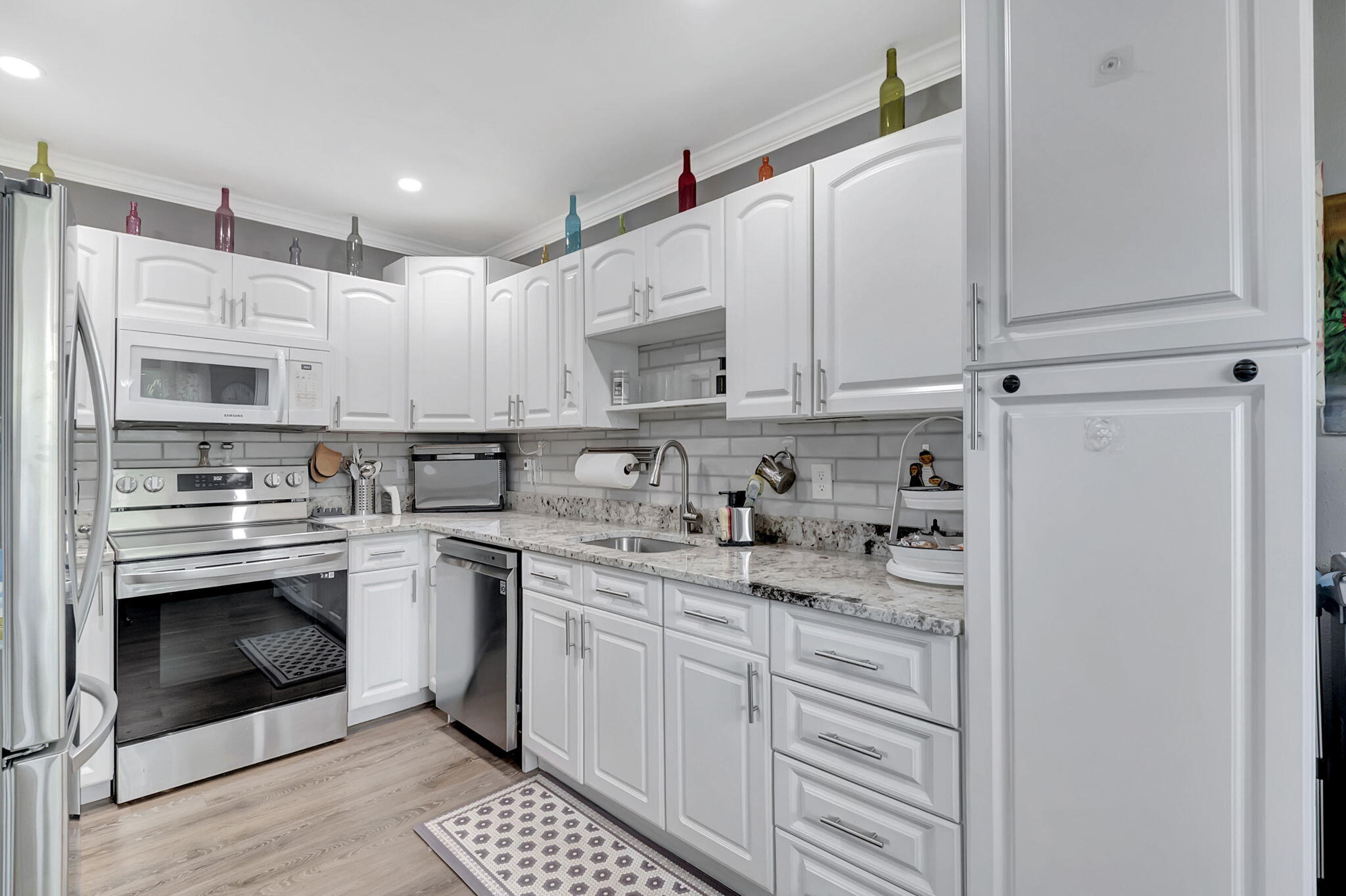 a kitchen with stainless steel appliances granite countertop a stove a sink and a refrigerator