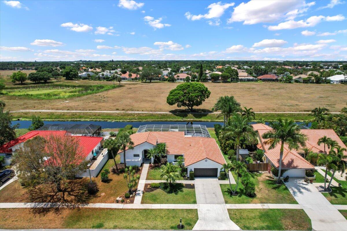 an aerial view of a house with a garden and lake view