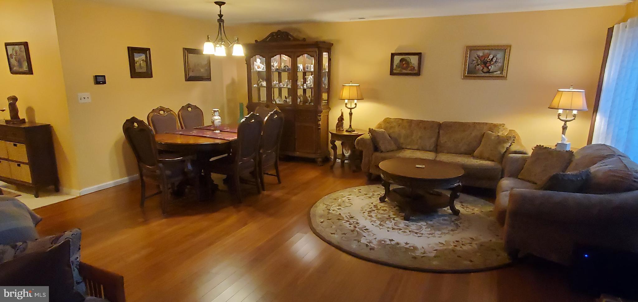 a living room with furniture a dining table and a chandelier