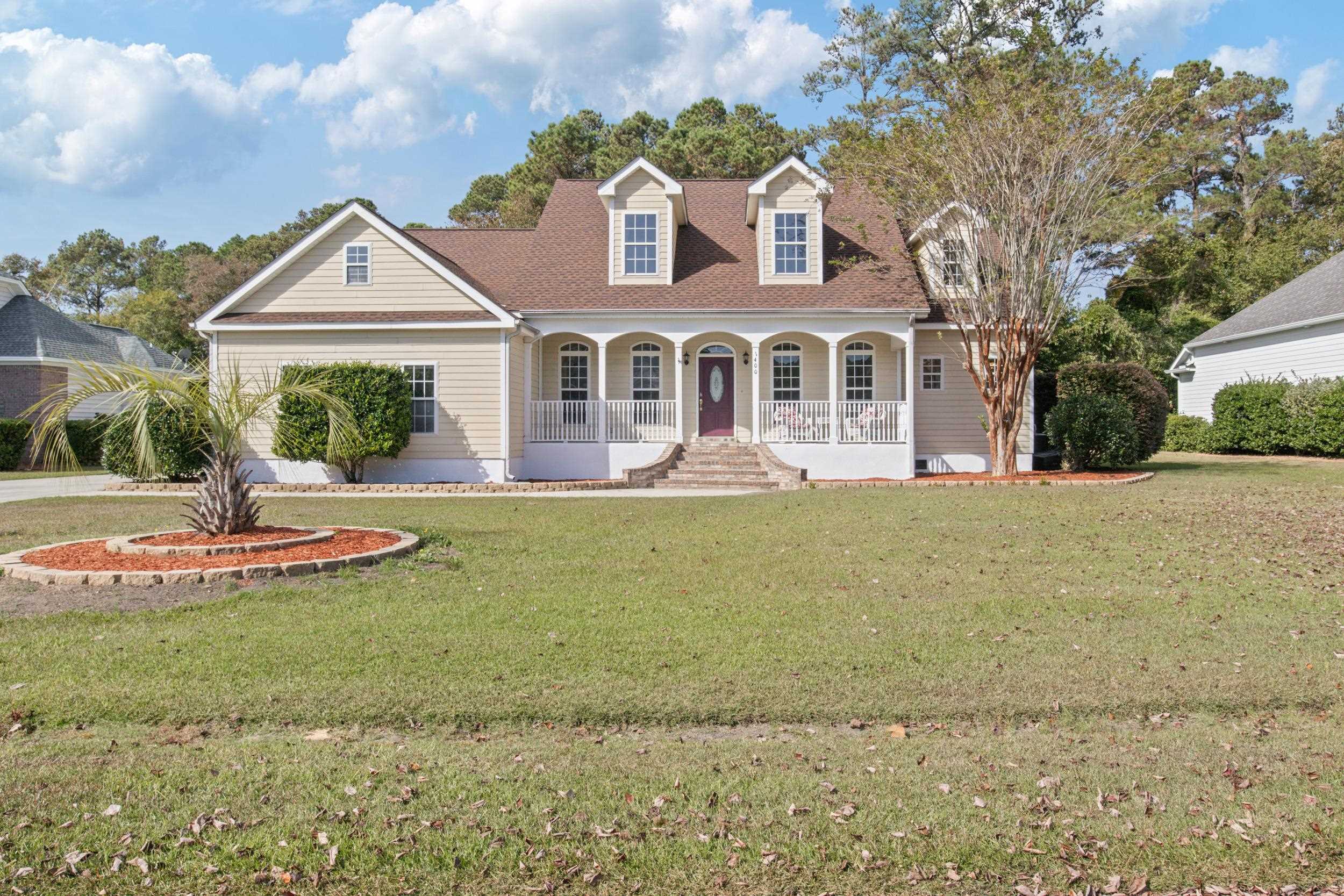 Cape cod home featuring a porch and a front yard