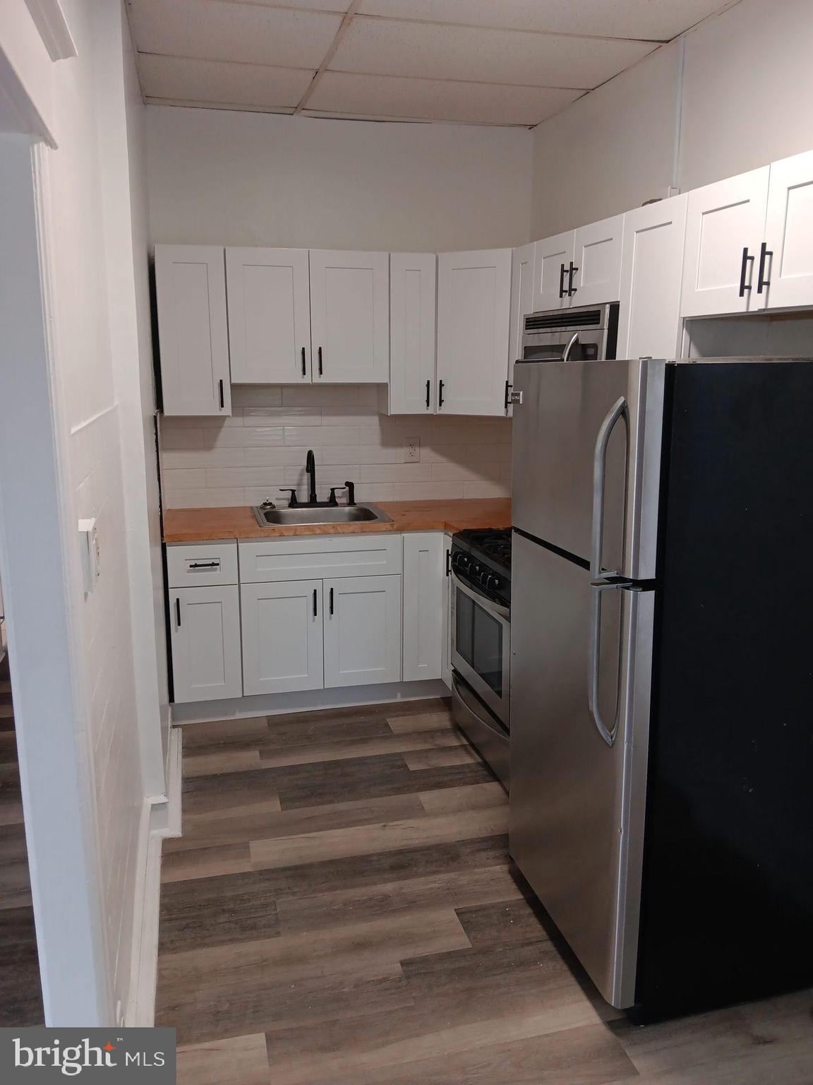 a kitchen with granite countertop a refrigerator and a sink