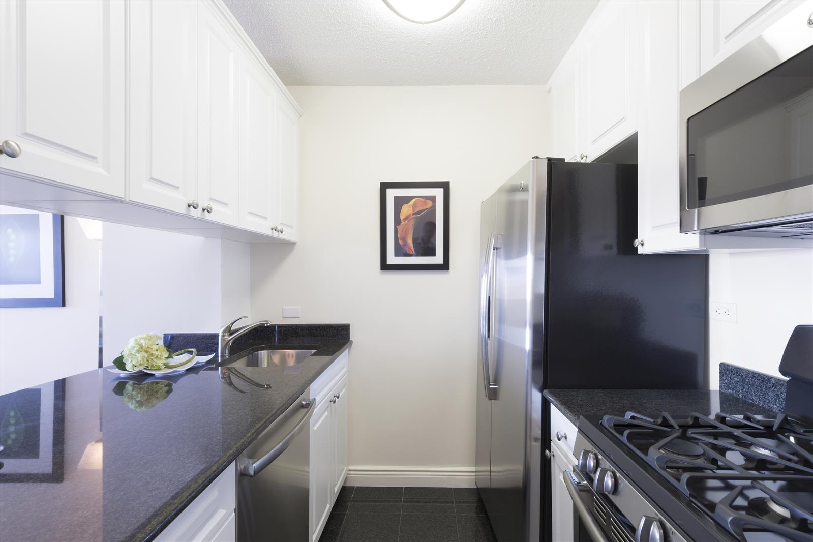 a kitchen with stainless steel appliances granite countertop a refrigerator and a stove top oven