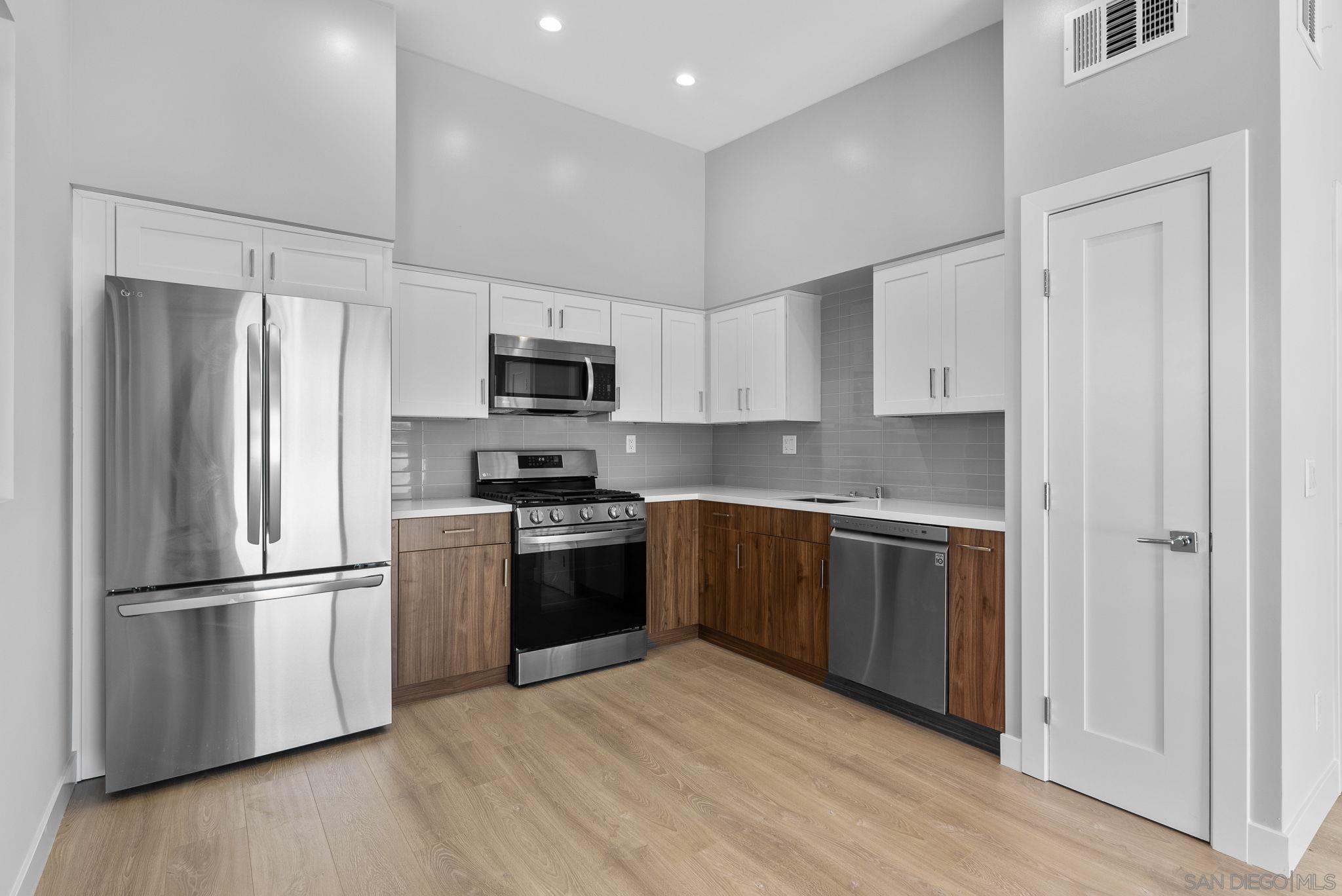 a kitchen with a refrigerator stove and wooden cabinets