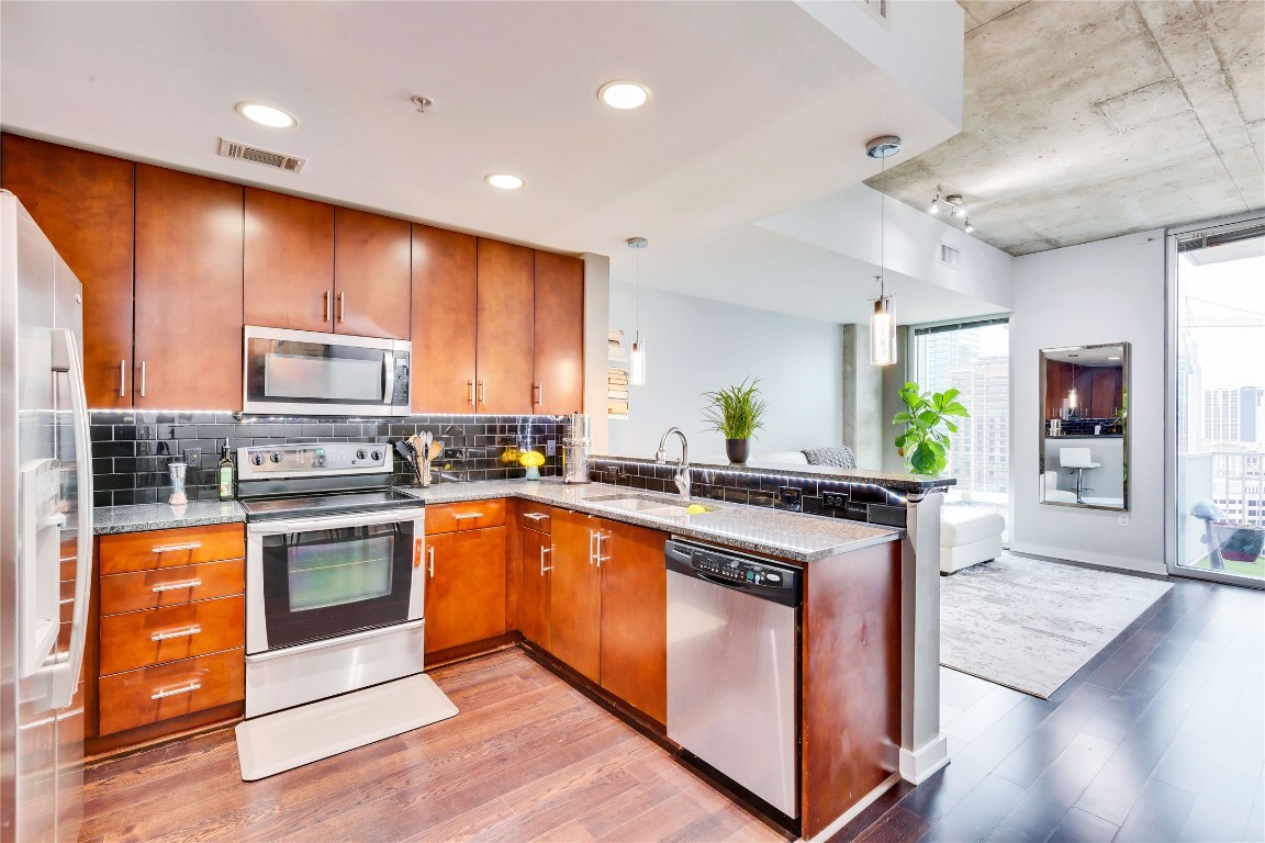 a large kitchen with stainless steel appliances granite countertop a stove and a sink