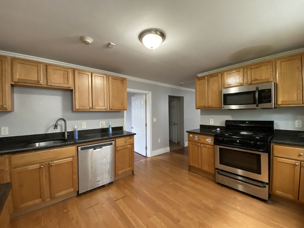 a kitchen with stainless steel appliances granite countertop a stove a sink and a microwave