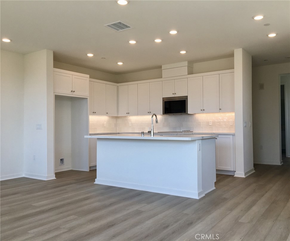 a kitchen with granite countertop white cabinets and stainless steel appliances