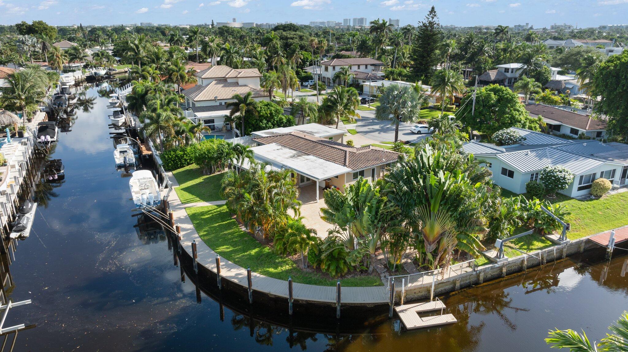 an aerial view of a house with a yard lake and outdoor seating