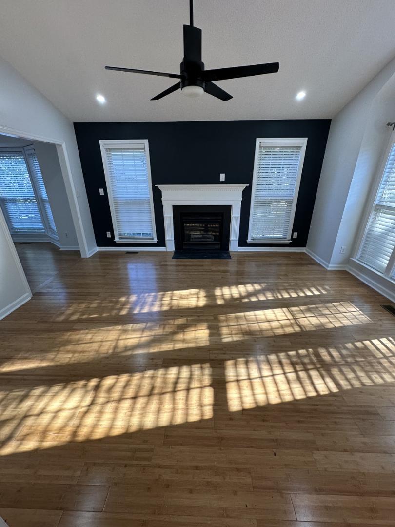 a view of empty room with wooden floor and fireplace