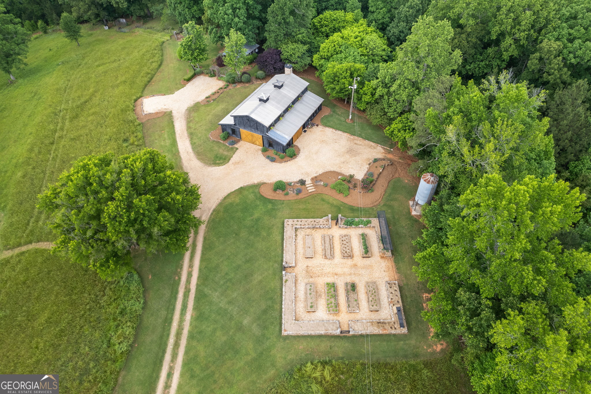 an aerial view of a house with a garden and trees