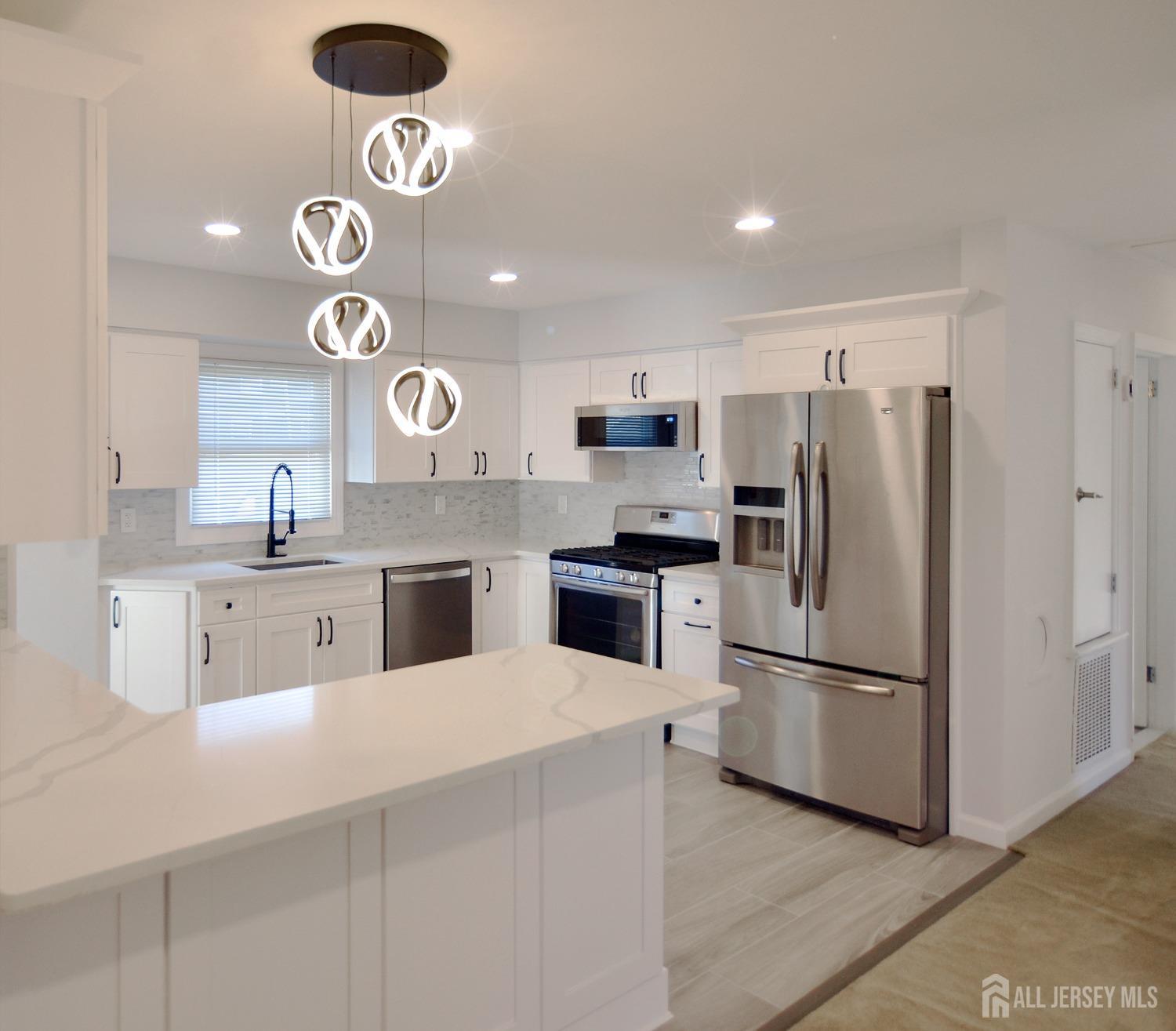 a kitchen with a refrigerator a microwave oven and a sink