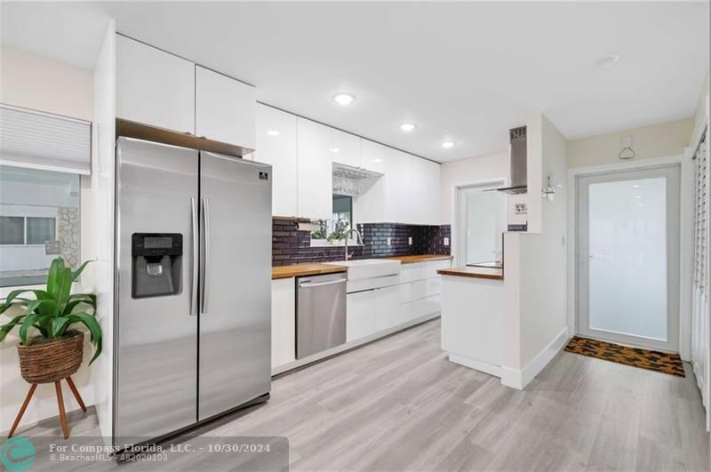 a kitchen with a refrigerator and a white wooden cabinets