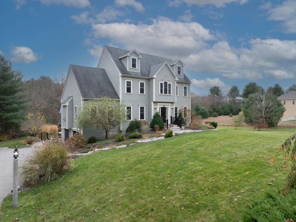 a view of a house with a big yard and large trees