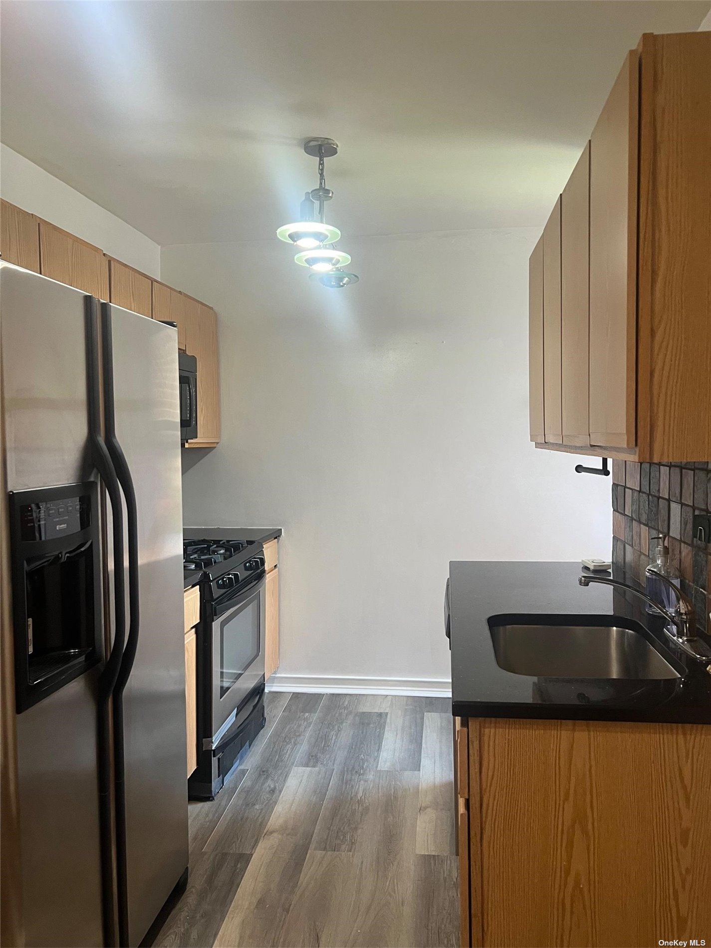 a kitchen with stainless steel appliances granite countertop a sink stove and refrigerator