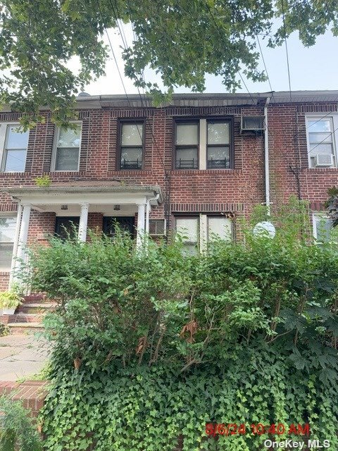 a front view of a house with plants and trees