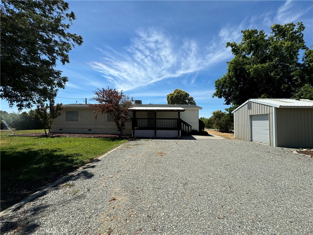 a front view of a house with a yard and tree s