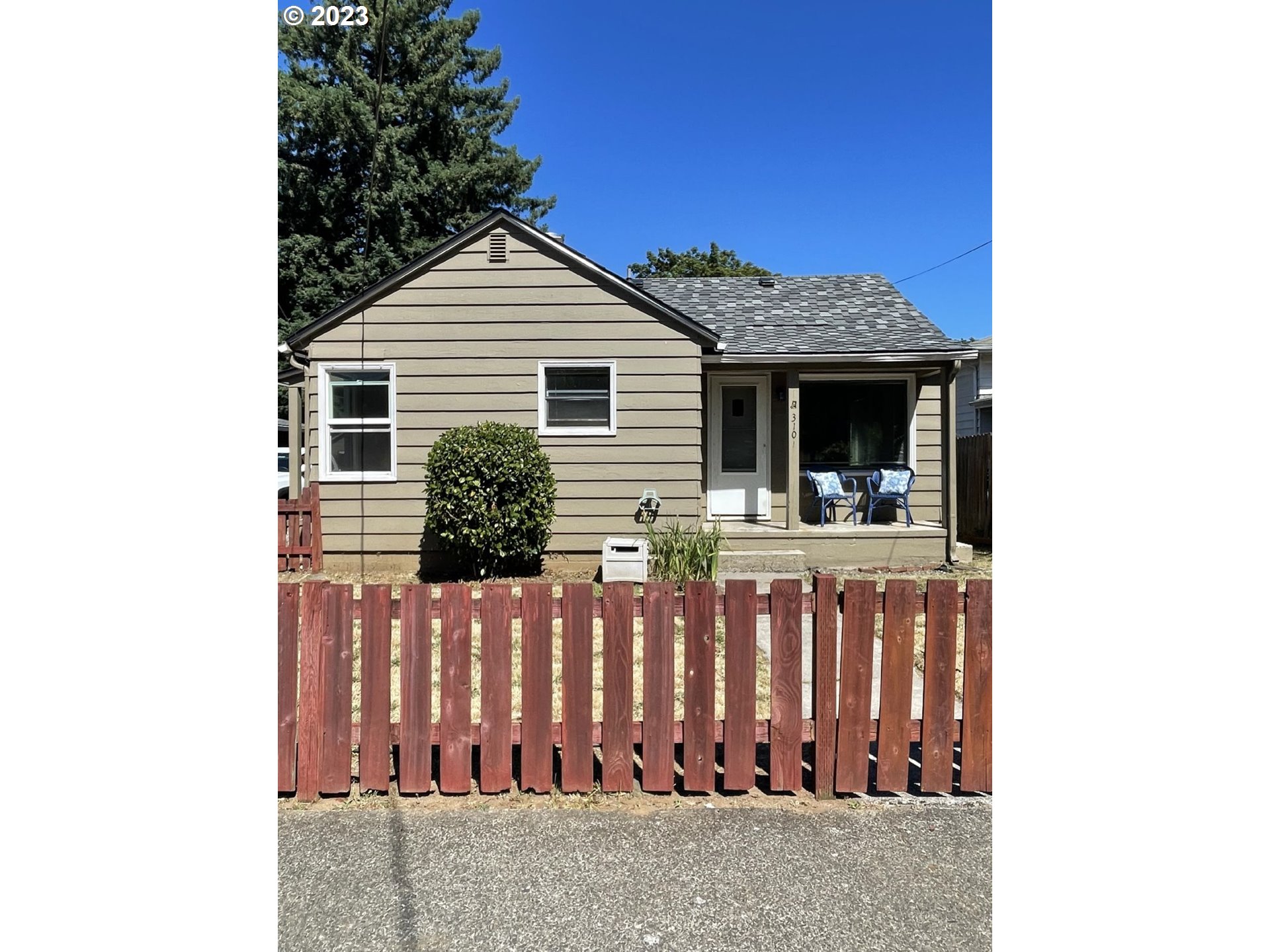 a view of a house with wooden fence