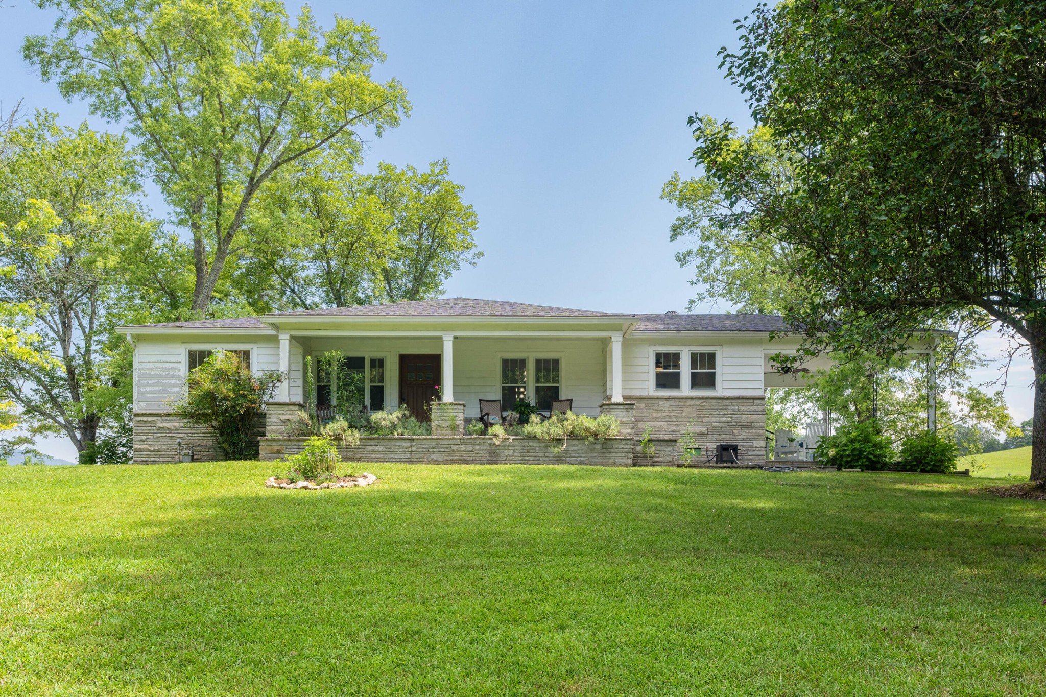 a front view of house with a garden and trees