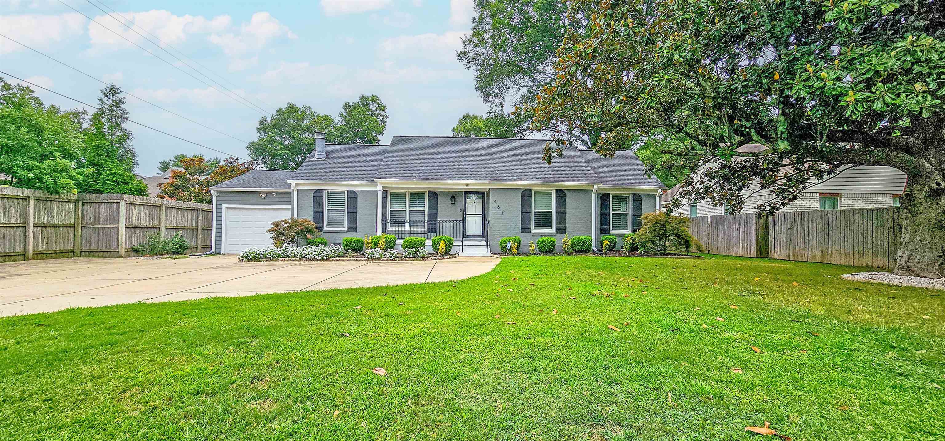 a front view of a house with a yard and green space