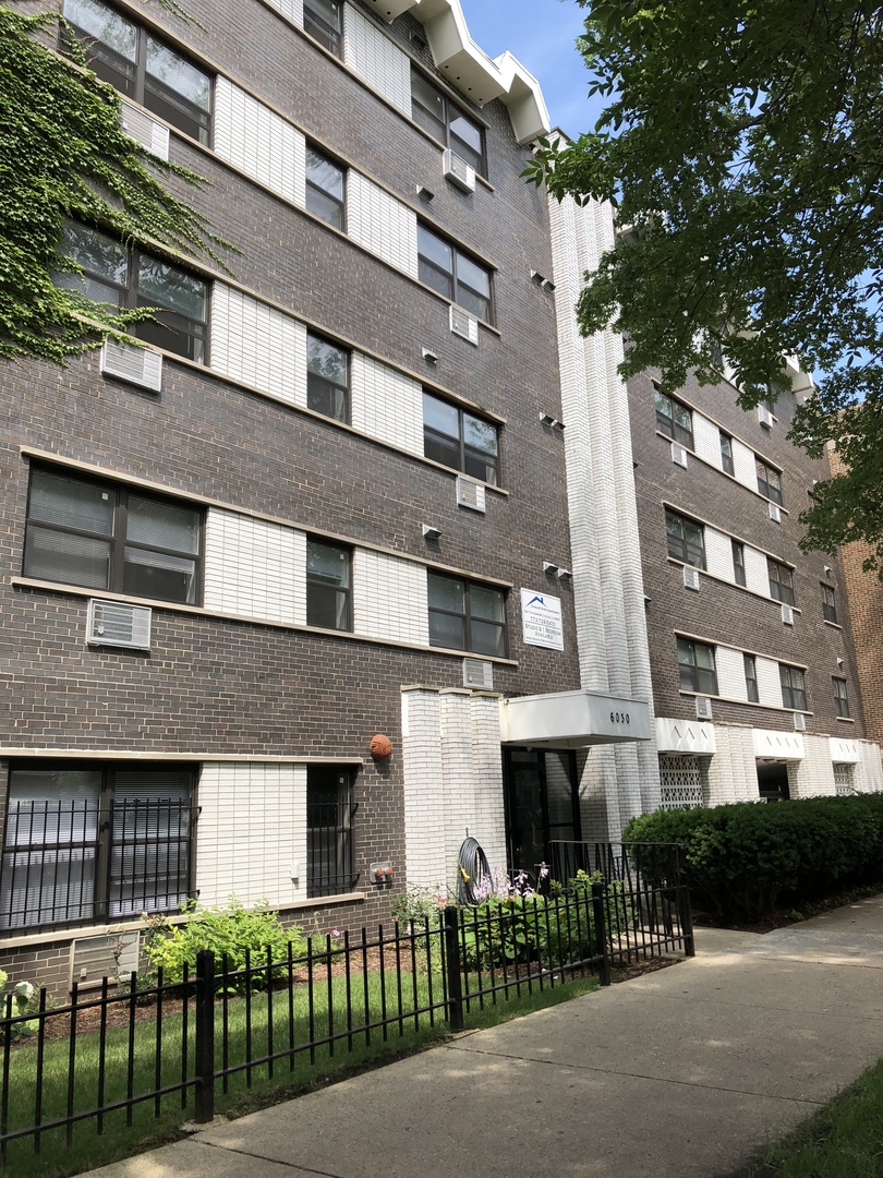 a front view of a building with a garden