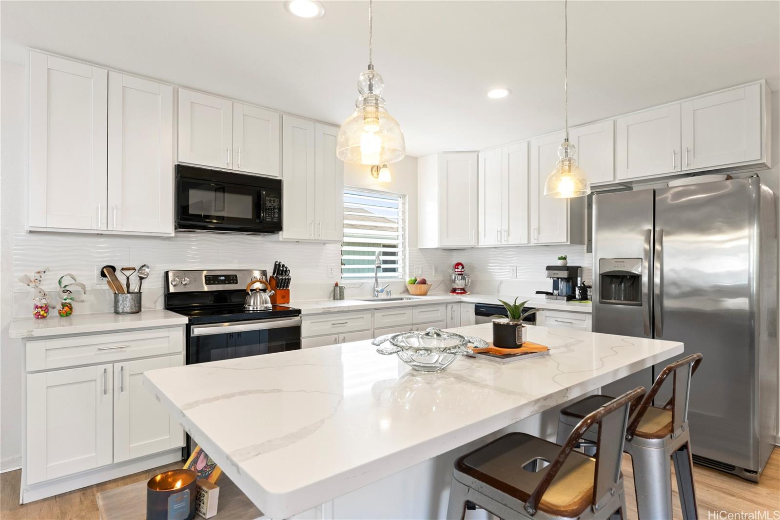 a kitchen with a sink a stove a refrigerator and white cabinets with wooden floor