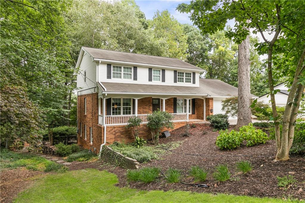 a front view of house with yard and trees around