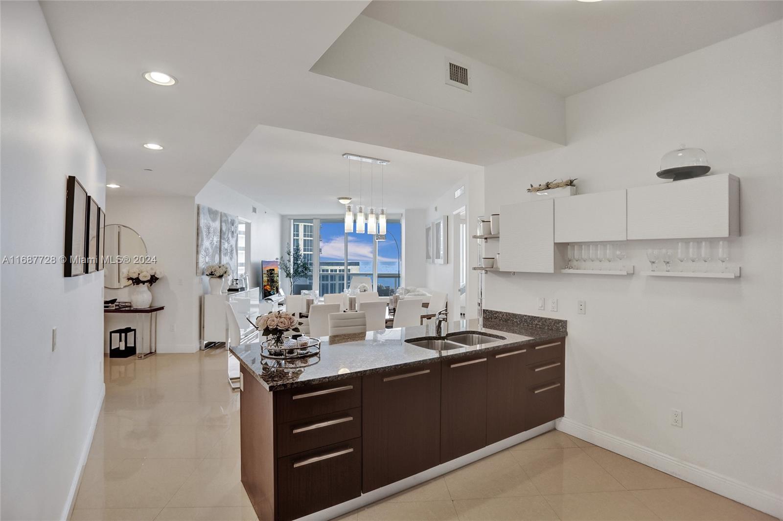 a kitchen with granite countertop a sink cabinets and stainless steel appliances