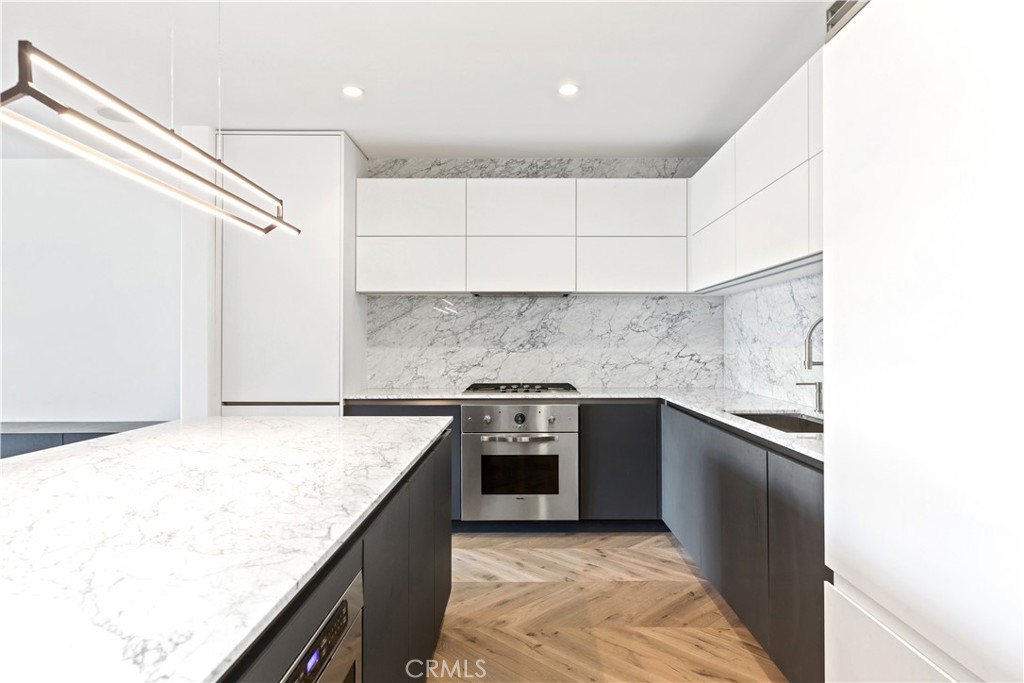 a kitchen with granite countertop a stove sink and cabinets