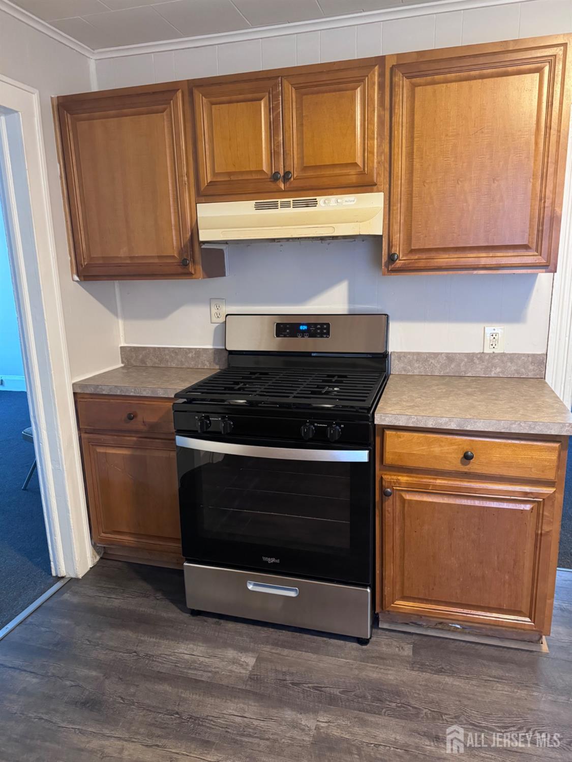 a kitchen with granite countertop wooden cabinets and a stove top oven