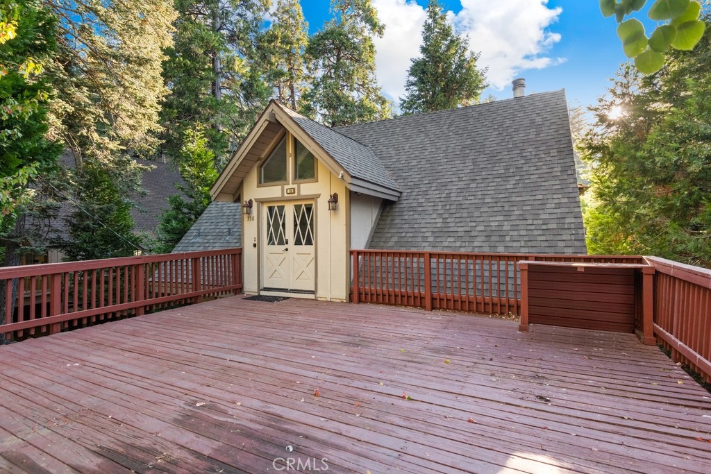 a view of a house with wooden deck and a yard