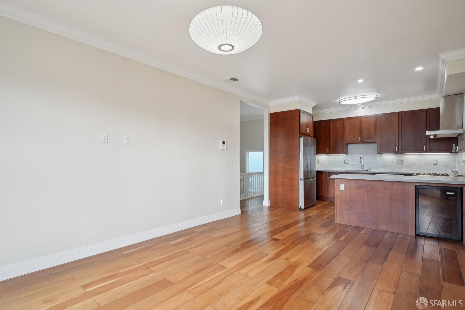 a large kitchen with a wooden floor and stainless steel appliances