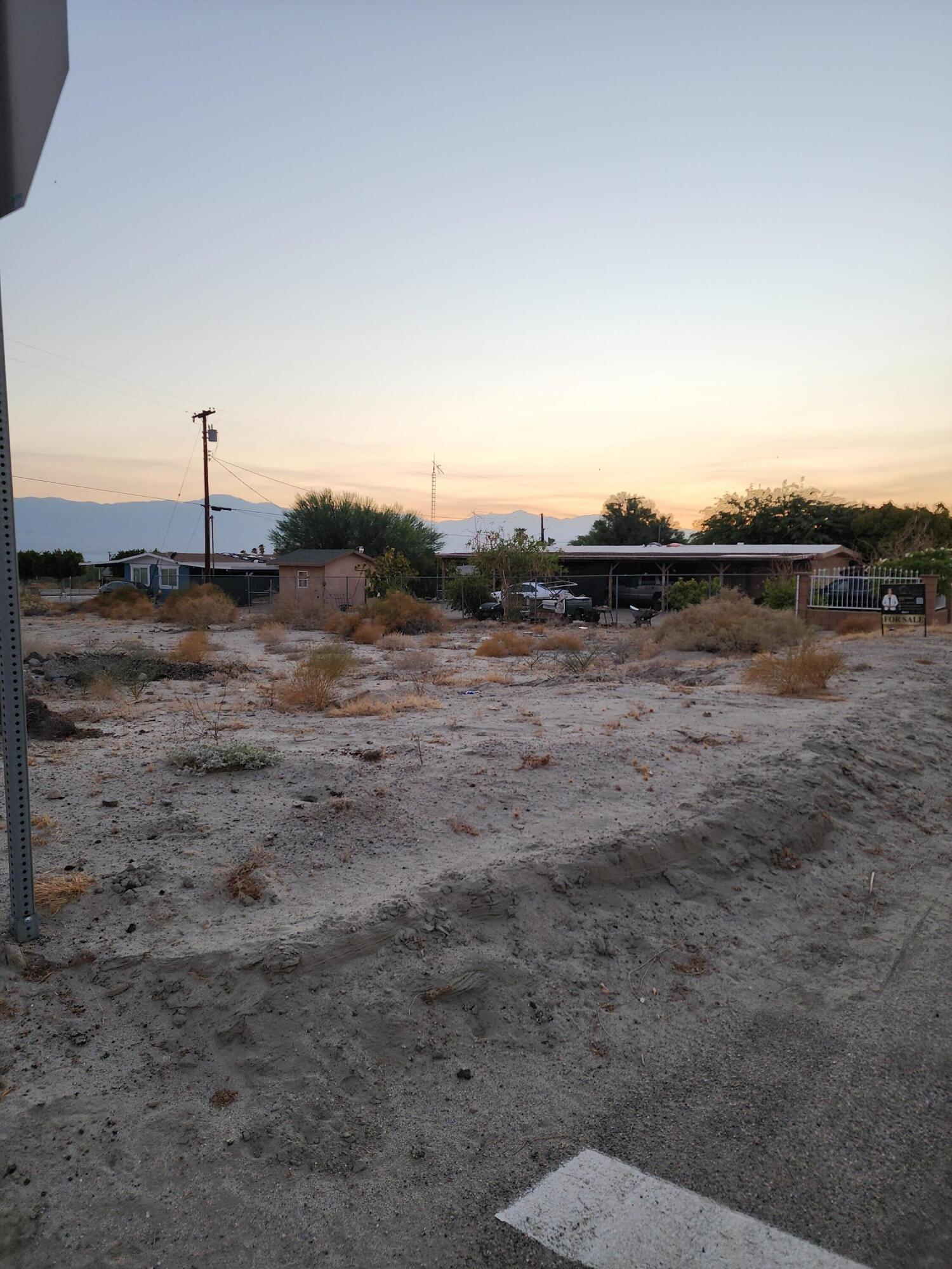 a view of a dry yard with wooden fence