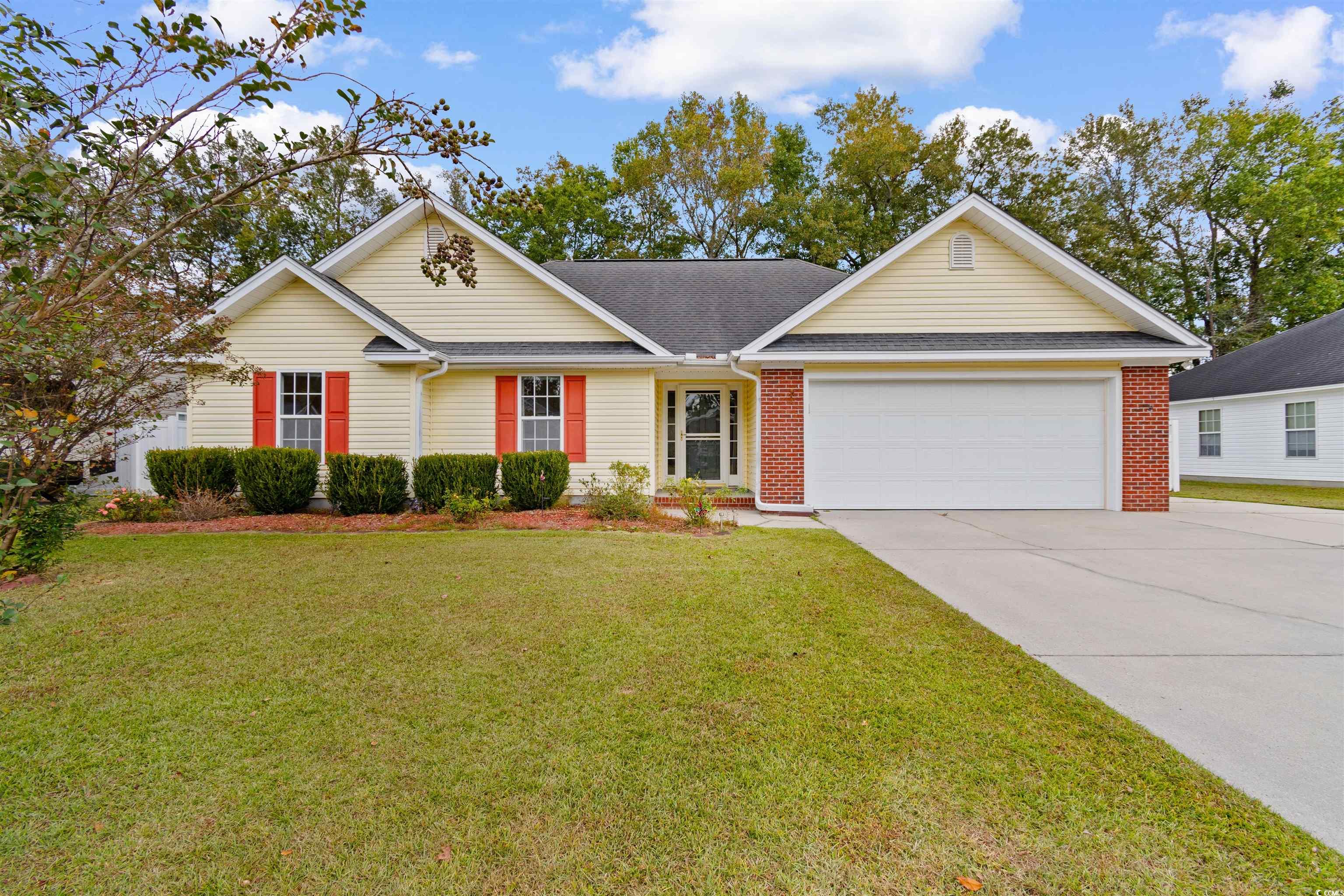 Ranch-style house with a front yard and a garage